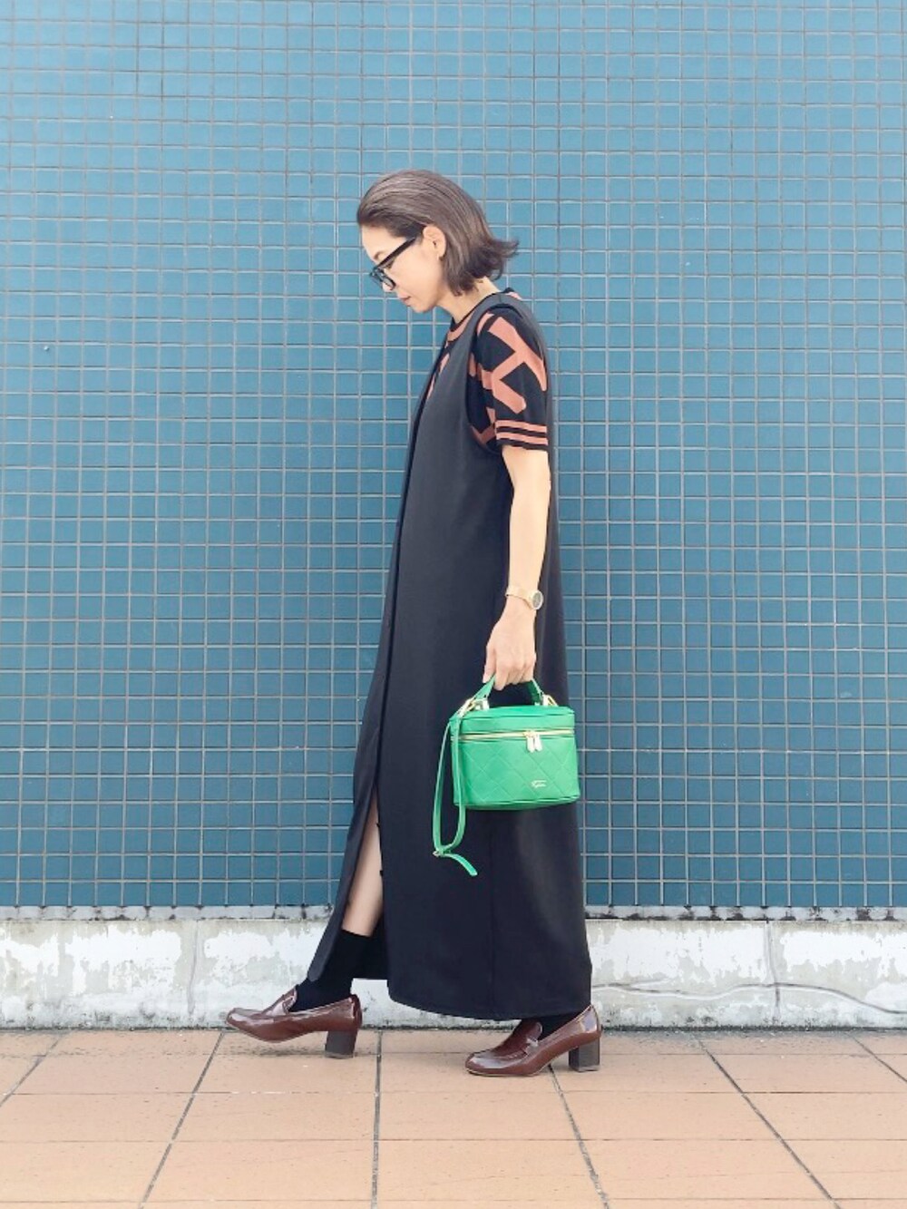 ブラウン系のその他トップス、ブラック系のジャンパースカート、グリーン系のショルダーバッグを着用したレディースの秋コーディネートの2枚目の写真