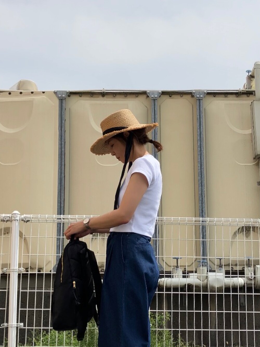 ホワイト系のTシャツ/カットソー、ブルー系のデニムパンツ、ブラック系のサンダルを着用したレディースの春コーディネートの3枚目の写真