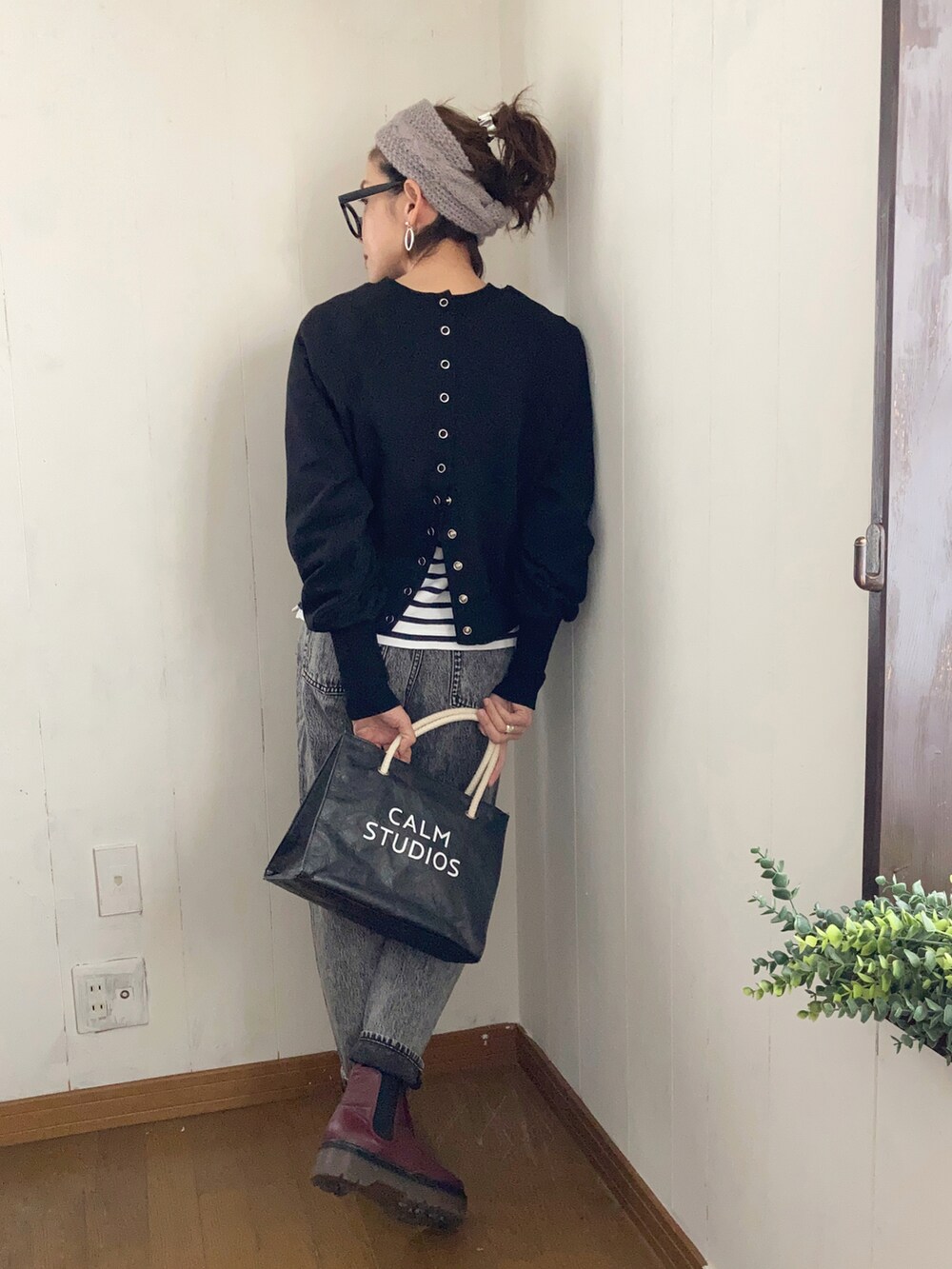 ブラック系のスウェット、ブラック系のトートバッグ、グレー系のデニムパンツを着用したレディースの冬コーディネートの2枚目の写真
