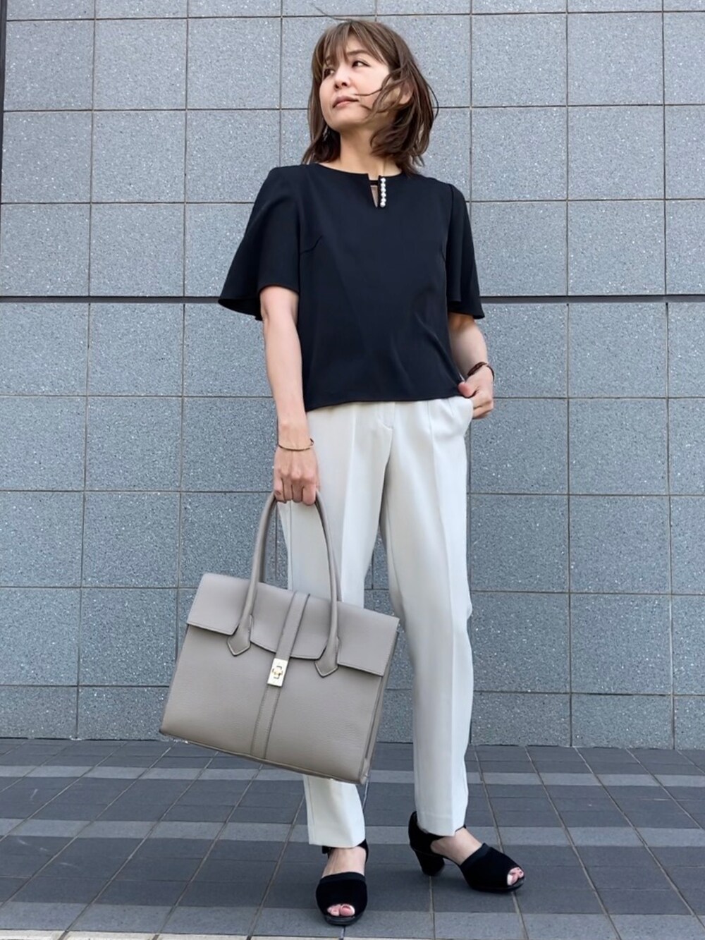 ブラック系のシャツ/ブラウス、ホワイト系のパンツ、ブラック系のサンダルを着用したレディースの春コーディネートの3枚目の写真