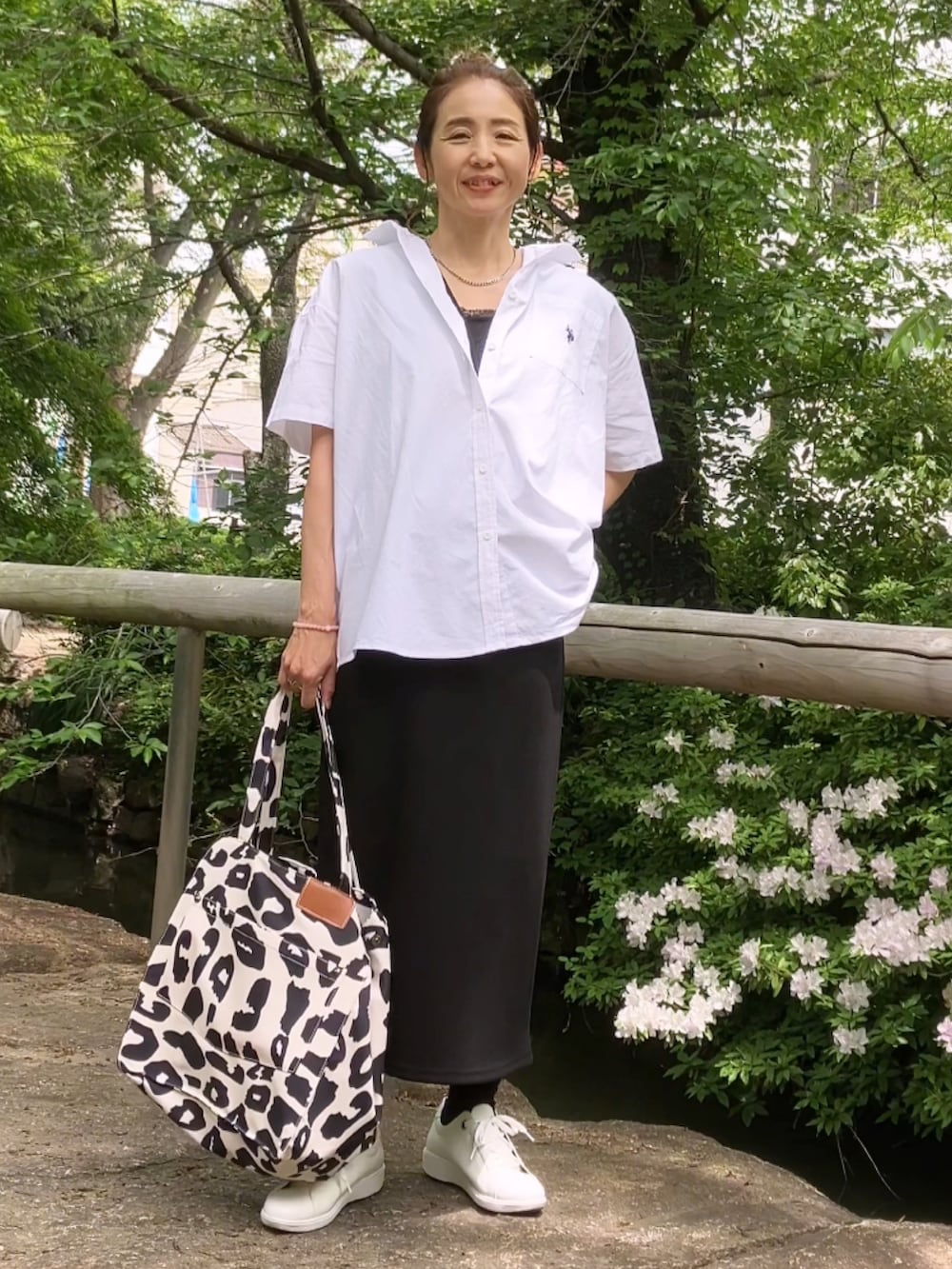 ホワイト系のシャツ/ブラウス、ブラック系のワンピース、ベージュ系のトートバッグを着用したレディースの春コーディネートの2枚目の写真