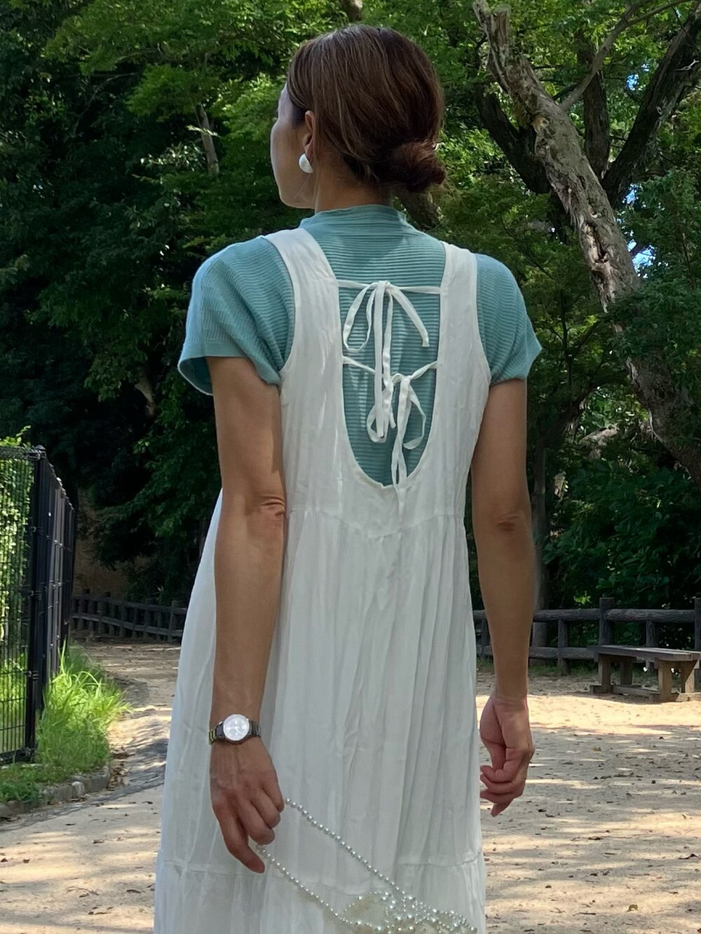 ホワイト系のワンピース、グリーン系のニット/セーター、ホワイト系のハンドバッグを着用したレディースの夏コーディネートの3枚目の写真