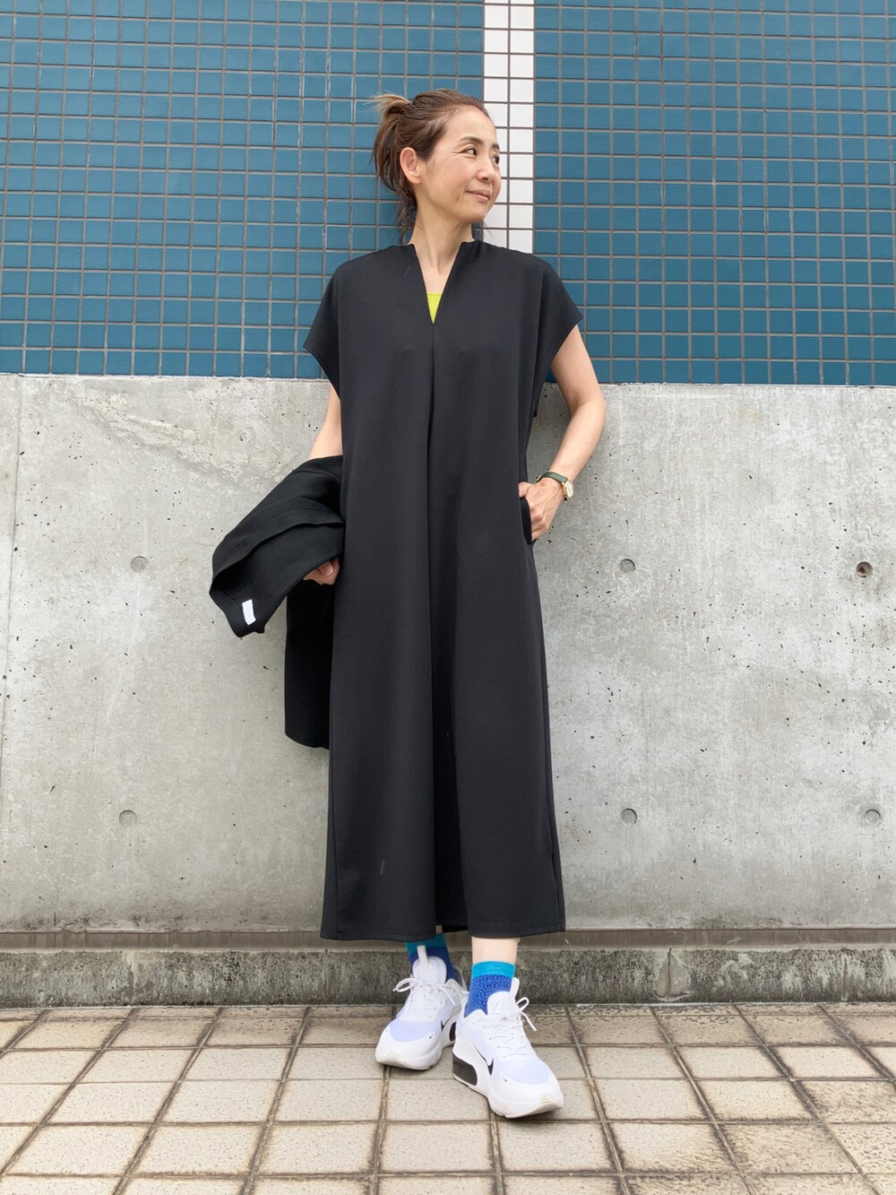 ブラック系のワンピース、ホワイト系のスニーカー、ホワイト系のリングを着用したレディースの春コーディネートの3枚目の写真