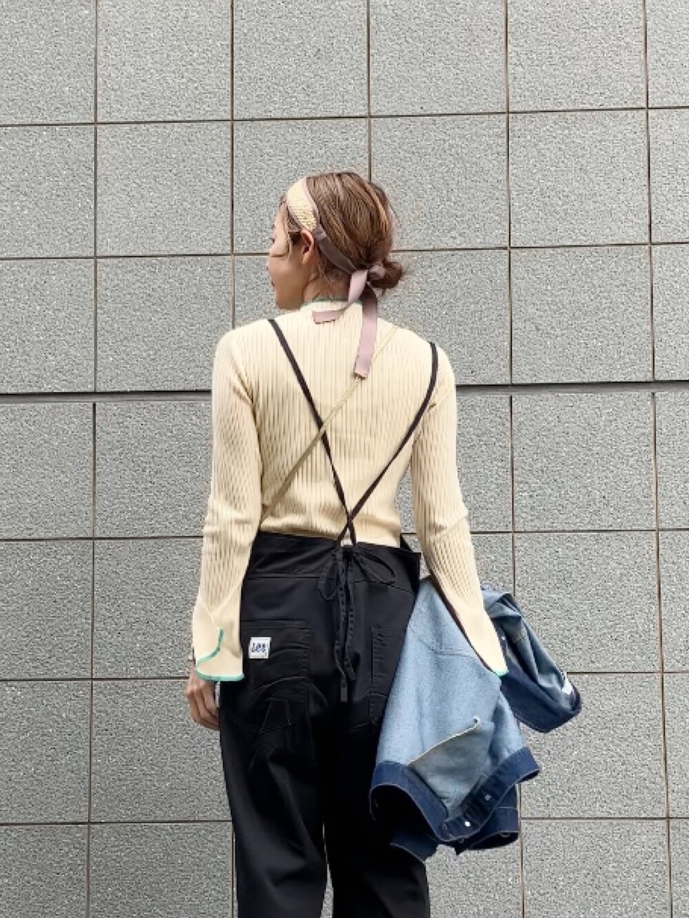 ブラック系のサロペット/オーバーオール、ホワイト系のニット/セーター、ブルー系のデニムジャケットを着用したレディースの春コーディネートの4枚目の写真