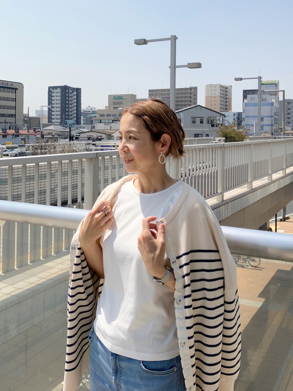 ホワイト系のTシャツ/カットソー、ブルー系のデニムパンツ、ブルー系のカーディガン/ボレロを着用したレディースの春コーディネートの4枚目の写真