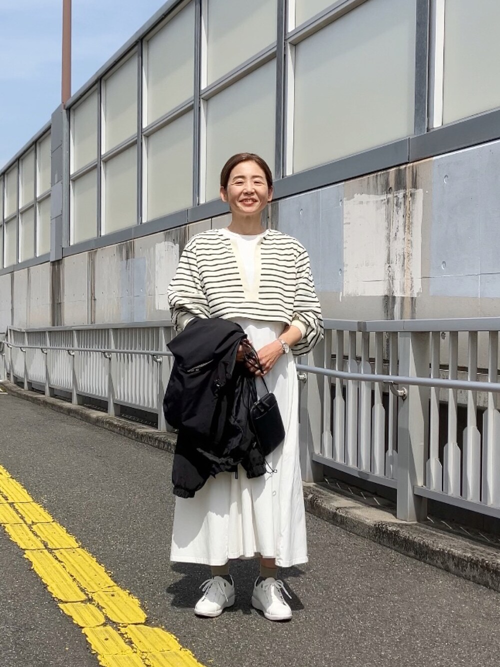 ホワイト系のワンピース、ホワイト系のスウェット、ブラック系のブルゾンを着用したレディースの春コーディネートの3枚目の写真