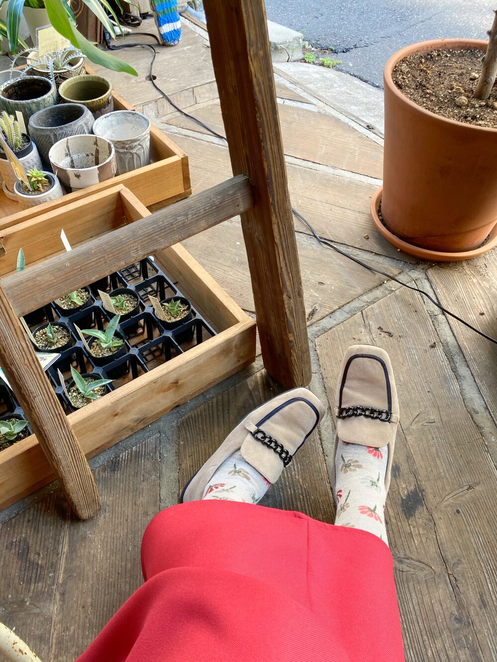 イエロー系のバックパック/リュック、ベージュ系のシューズ、レッド系のスカートを着用したレディースの秋コーディネートの4枚目の写真