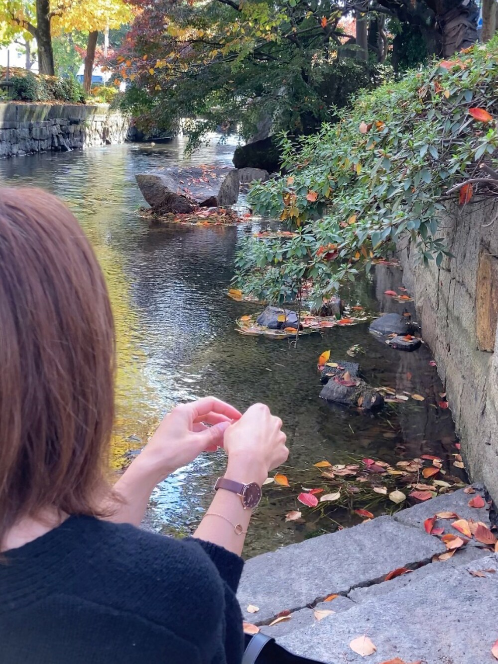 ブラック系のニット/セーター、ブラウン系のスカート、ブラック系のトートバッグを着用したレディースの秋コーディネートの2枚目の写真