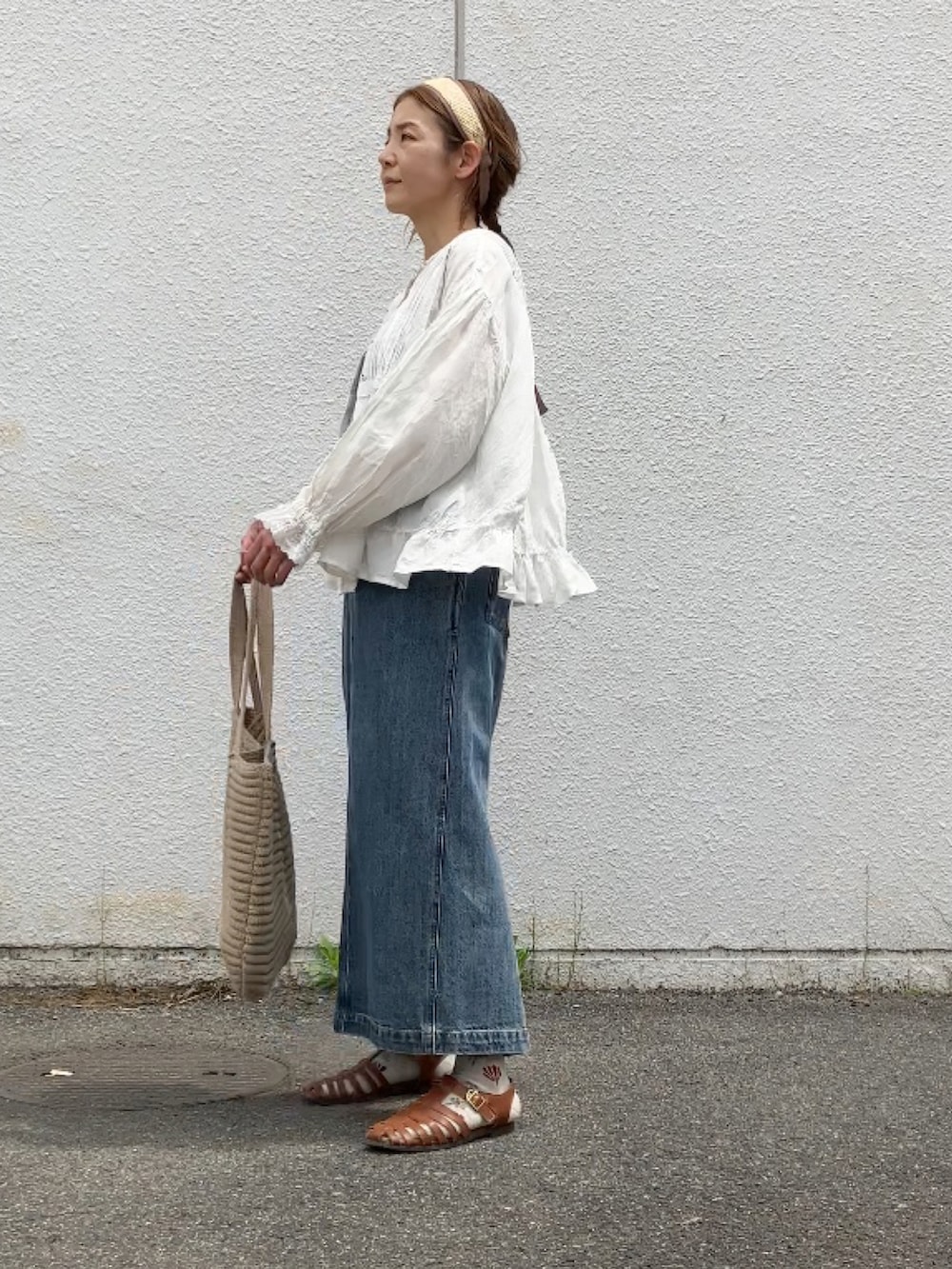 ブルー系のサロペット/オーバーオール、ホワイト系のシャツ/ブラウス、ブラウン系のサンダルを着用したレディースの春コーディネートの4枚目の写真