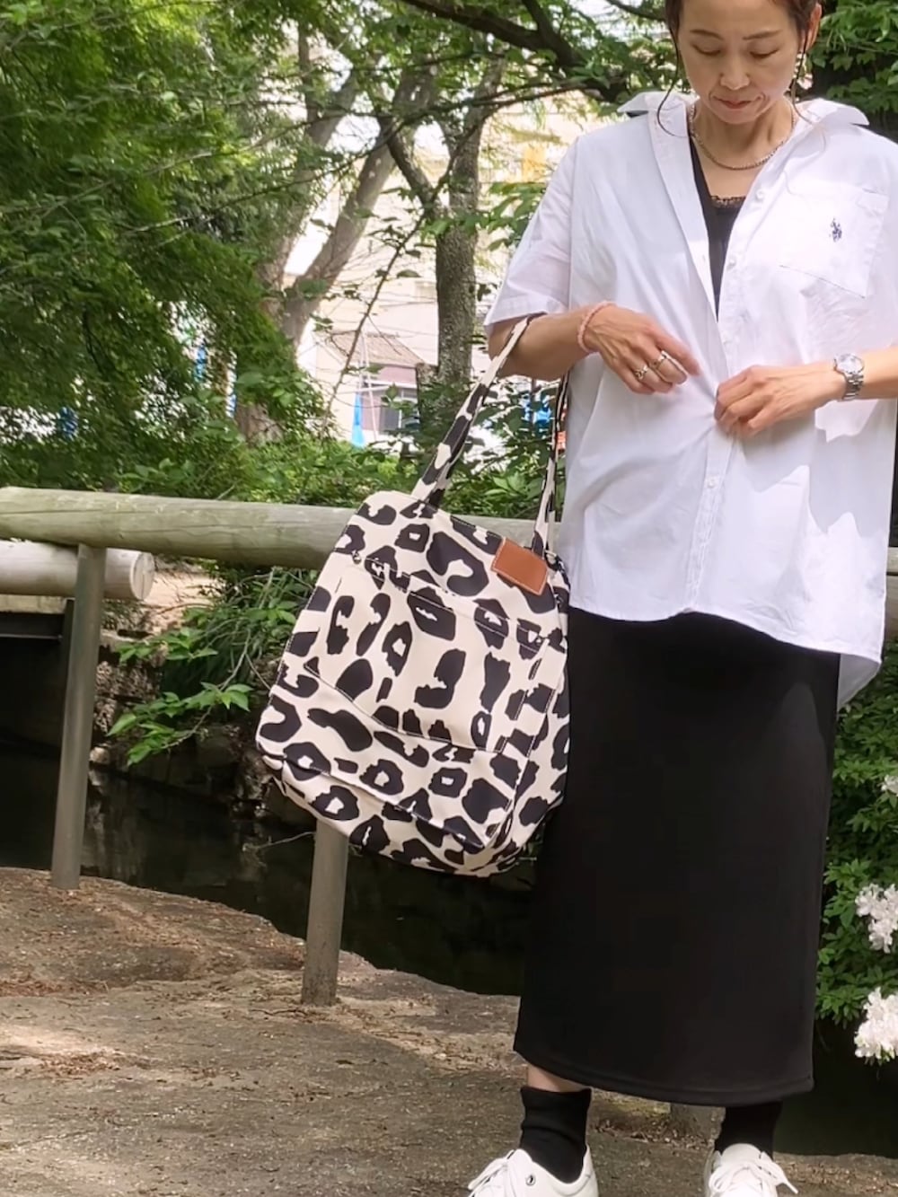 ホワイト系のシャツ/ブラウス、ブラック系のワンピース、ベージュ系のトートバッグを着用したレディースの春コーディネートの3枚目の写真