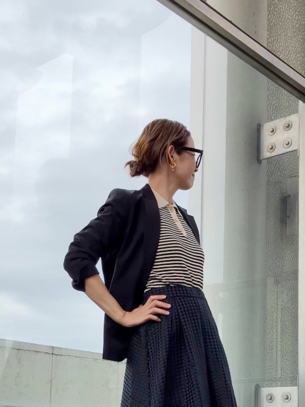 ブラック系のトップス、ブラック系のスカート、ブラック系のビジネスバッグを着用したレディースの春コーディネートの4枚目の写真