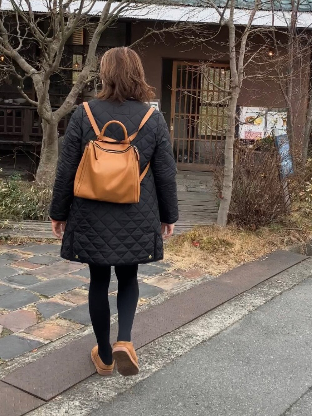 ホワイト系のTシャツ/カットソー、オレンジ系のカーディガン/ボレロ、ブラック系のその他アウターを着用したレディースの冬コーディネートの2枚目の写真