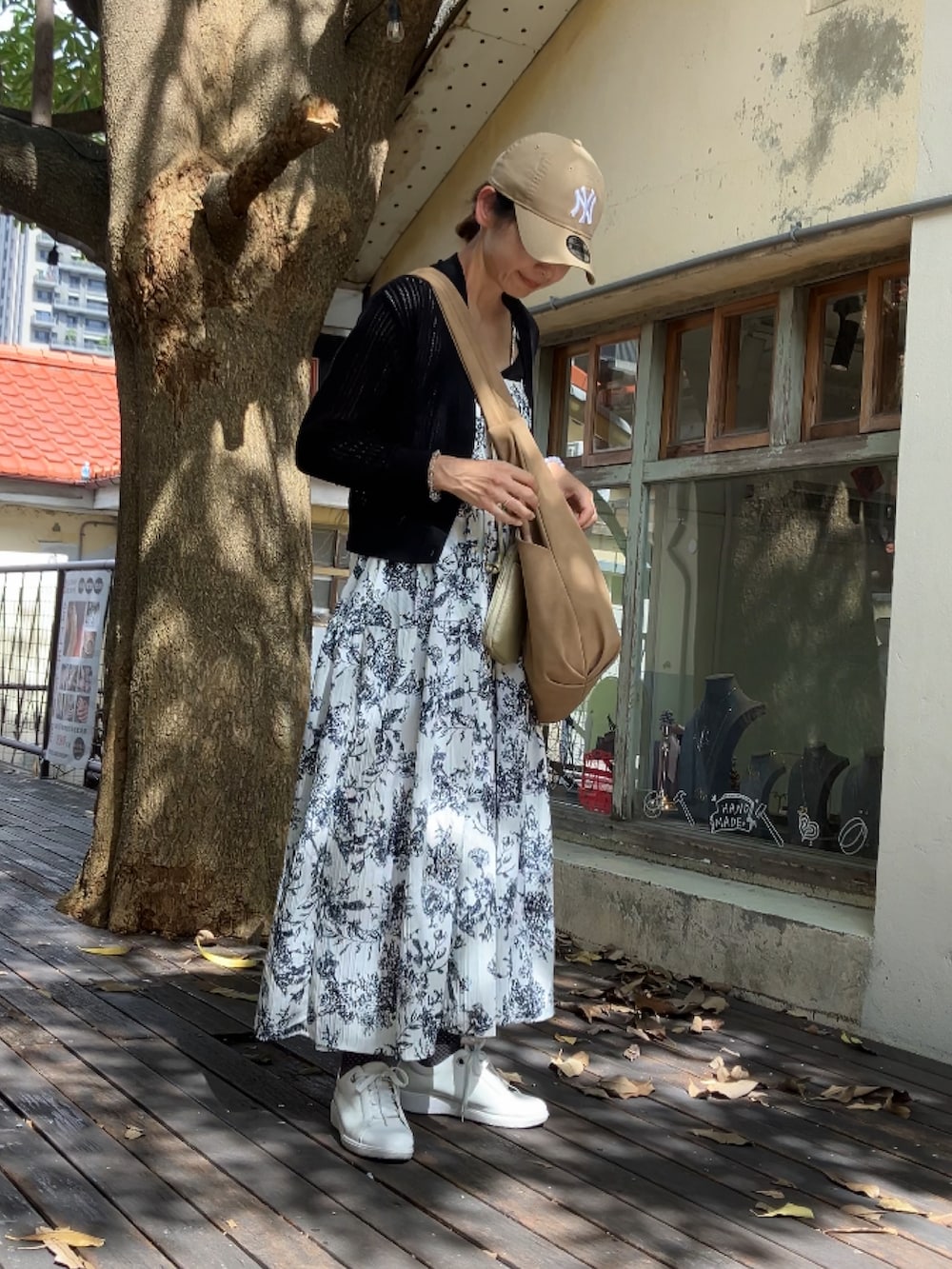 ベージュ系のショルダーバッグ、ホワイト系のワンピース/ドレス、ベージュ系のキャップを着用したレディースの夏コーディネートの2枚目の写真