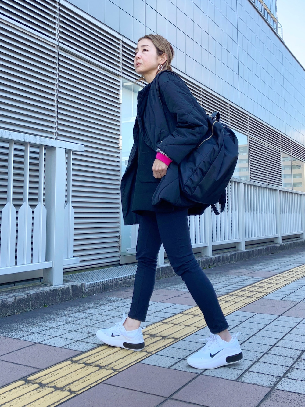 ブラック系のベスト、ブラック系のTシャツ/カットソー、ブラック系のダウンジャケット/コートを着用したレディースの春コーディネートの2枚目の写真