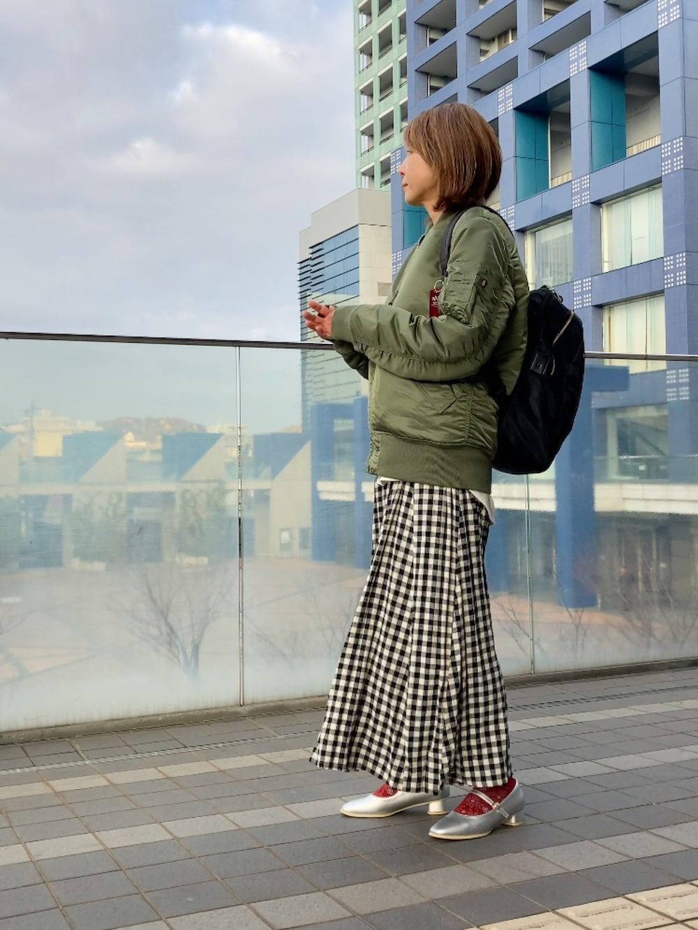 グリーン系のMA-1、ホワイト系のスウェット、グレー系のベストを着用したレディースの冬コーディネートの3枚目の写真