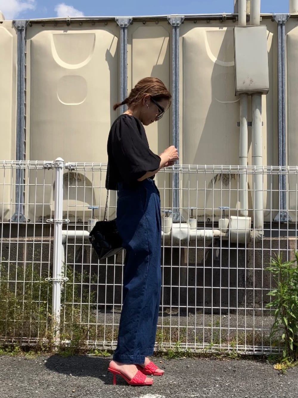 ブラック系のTシャツ/カットソー、ブルー系のデニムパンツ、ピンク系のサンダルを着用したレディースの春コーディネートの3枚目の写真