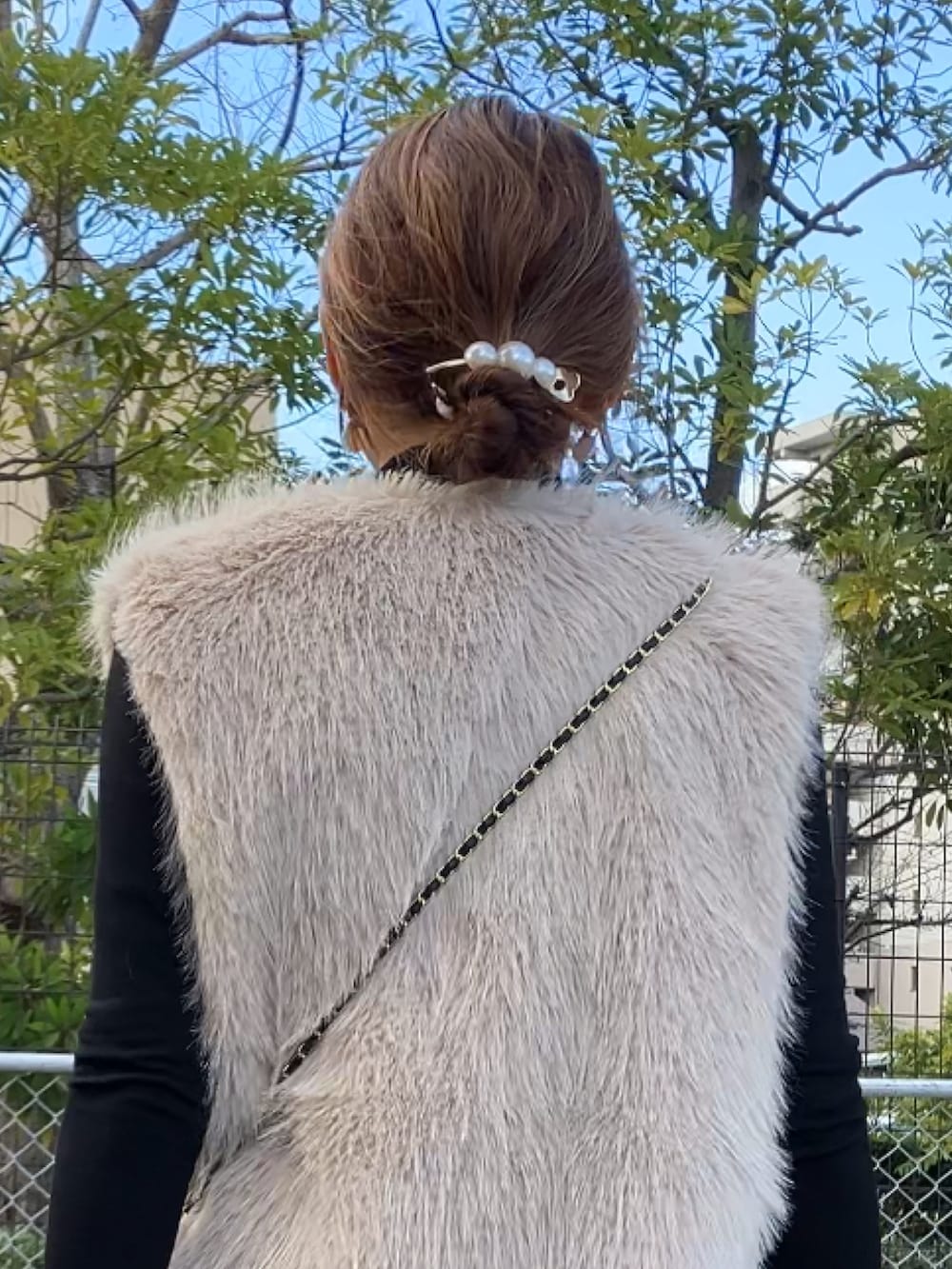 ブラック系のトップス、ベージュ系のベスト、その他のハンドバッグを着用したレディースの冬コーディネートの3枚目の写真