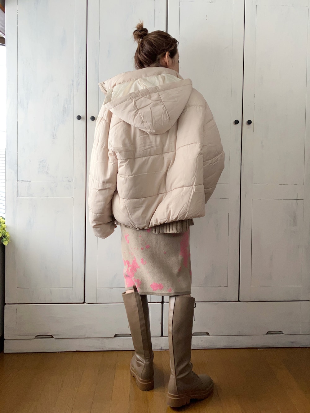 ベージュ系のスカート、ホワイト系のダウンジャケット/コート、ベージュ系のニット/セーターを着用したレディースの冬コーディネートの3枚目の写真