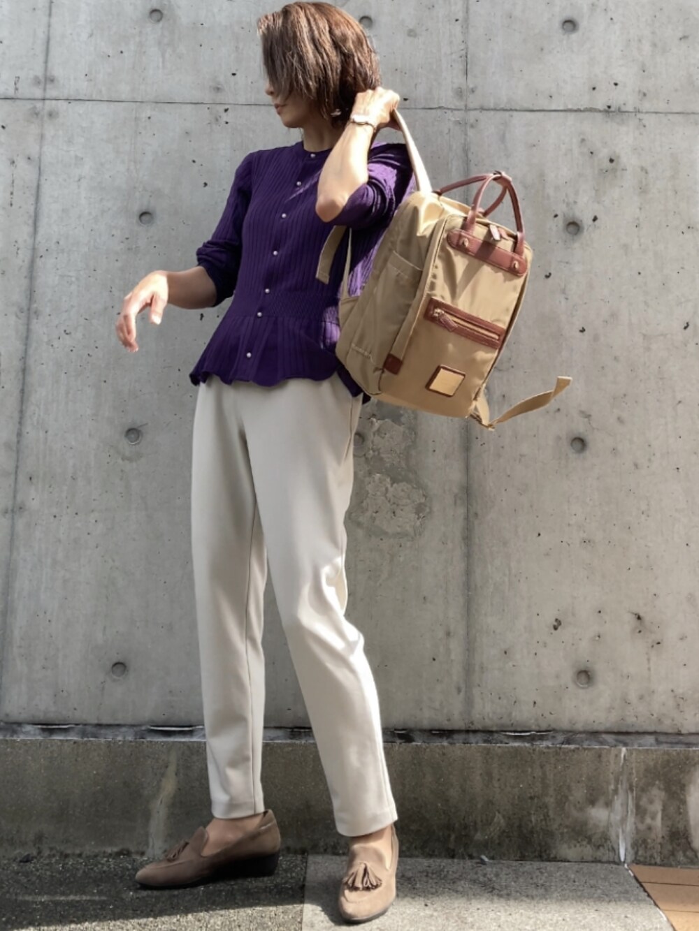 パープル系のカーディガン/ボレロ、ホワイト系のパンツ、ベージュ系のバックパック/リュックを着用したレディースの秋コーディネートの3枚目の写真