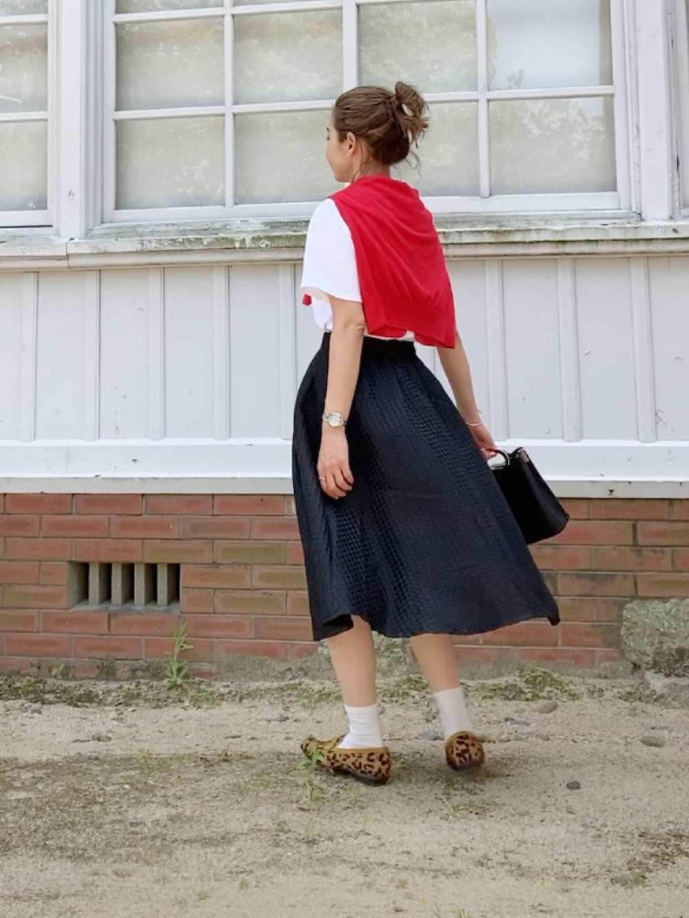 ベージュ系のローファー、ブラック系のハンドバッグ、ブラック系のスカートを着用したレディースの春コーディネートの2枚目の写真