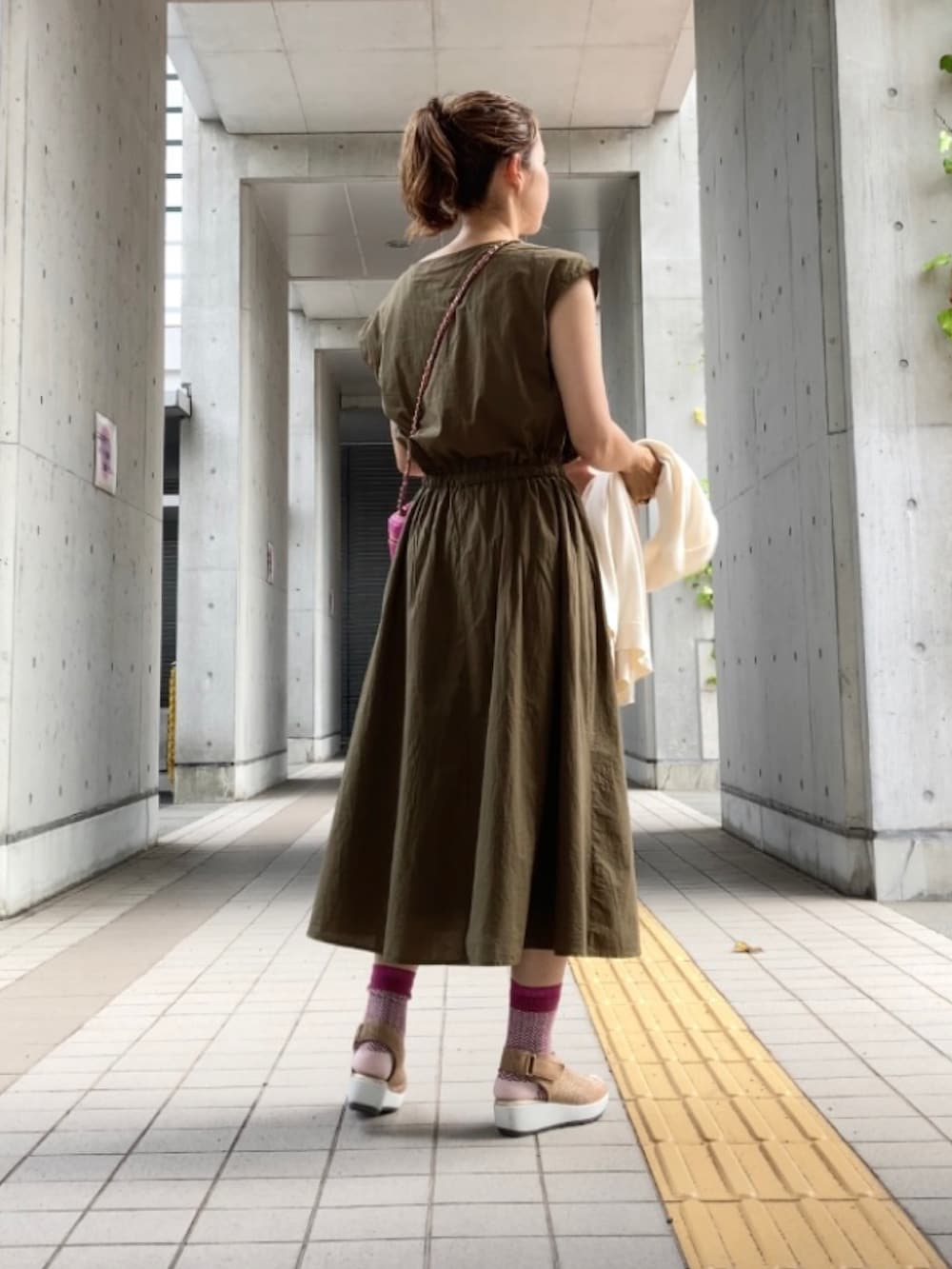 グリーン系のワンピース、ピンク系のショルダーバッグ、ゴールド系のサンダルを着用したレディースの夏コーディネートの3枚目の写真