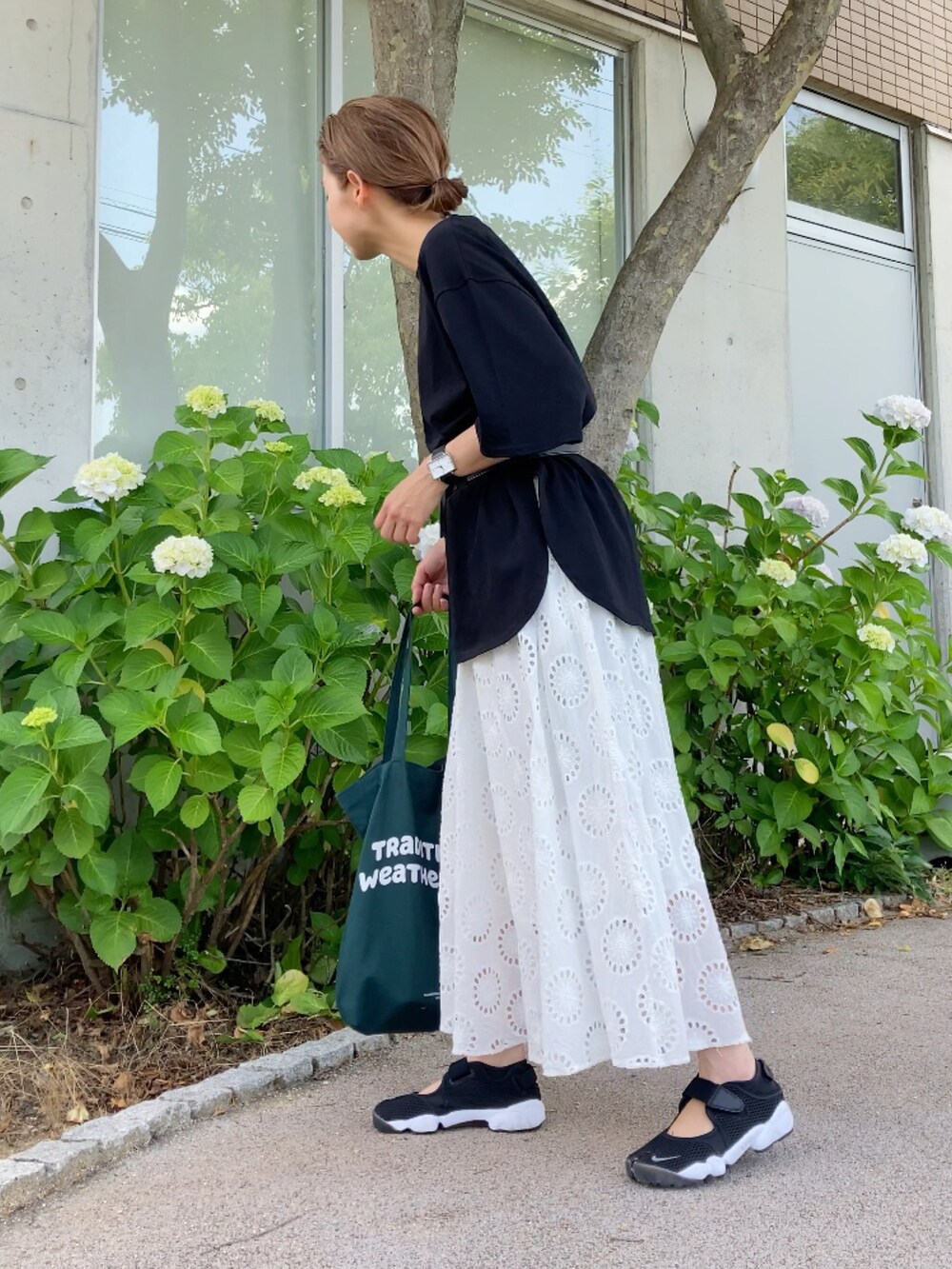 ブラック系のTシャツ/カットソー、ホワイト系のワンピース/ドレス、ブラック系のサンダルを着用したレディースの夏コーディネートの2枚目の写真