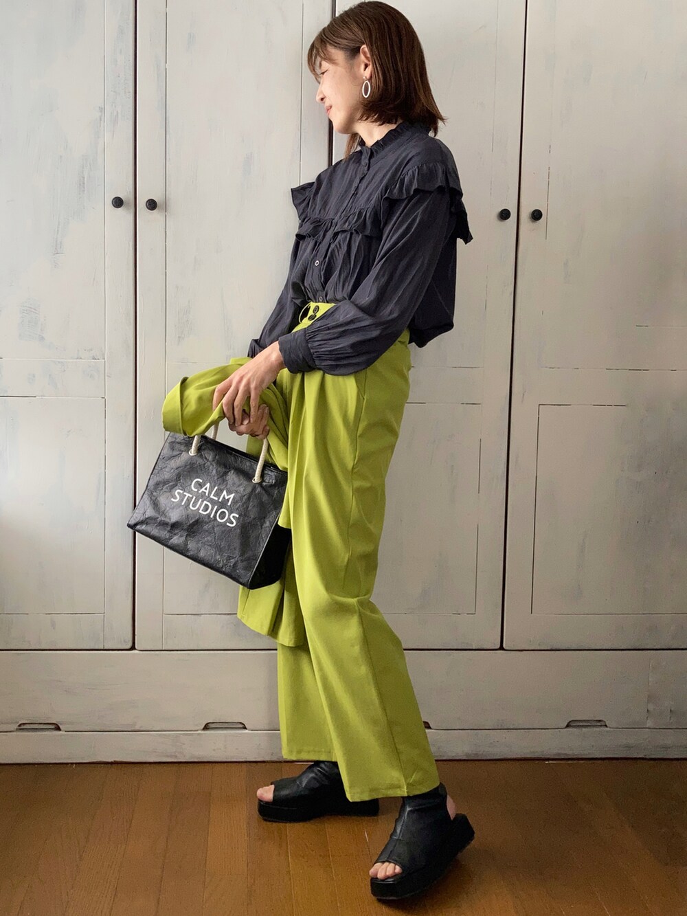 グリーン系のテーラードジャケット、ブラック系のシャツ/ブラウス、ブラック系のブーツを着用したレディースの春コーディネートの2枚目の写真