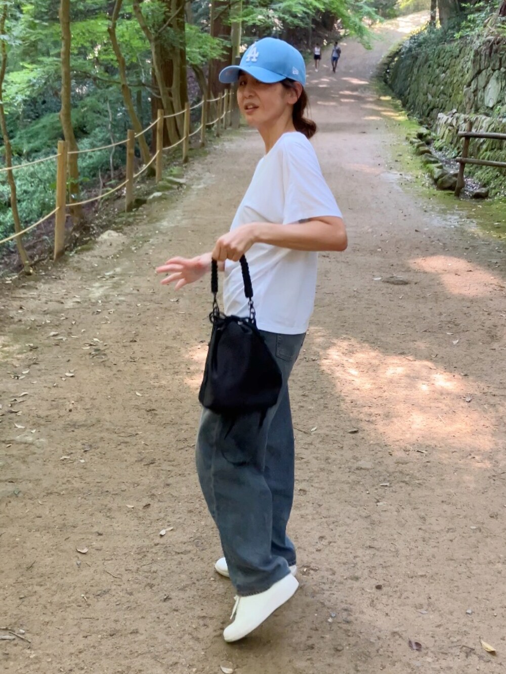 ブルー系のデニムパンツ、ブルー系のキャップを着用したレディースの夏コーディネートの2枚目の写真