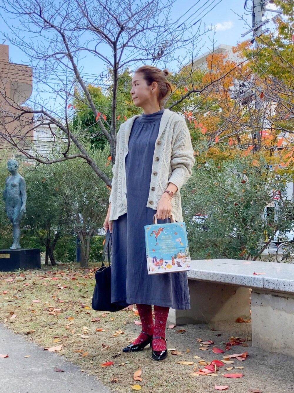 ホワイト系のカーディガン/ボレロ、グレー系のワンピース/ドレス、ブラック系のシューズを着用したレディースの秋コーディネートの4枚目の写真