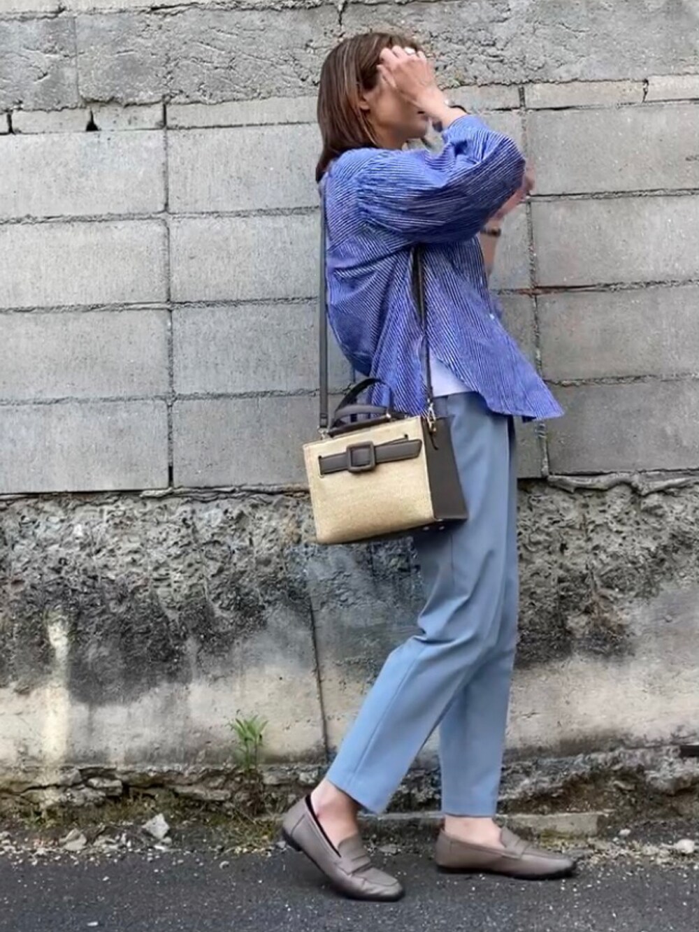 グレー系のハンドバッグ、ブルー系のシャツ/ブラウス、ブルー系のその他パンツを着用したレディースの春コーディネートの2枚目の写真