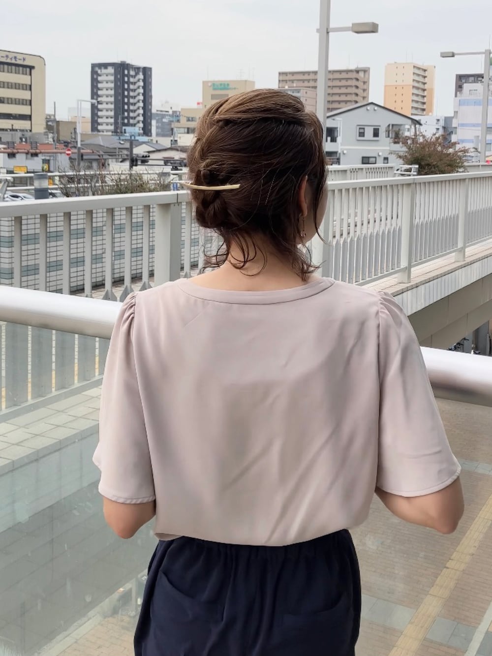 ベージュ系のシャツ/ブラウス、ブルー系のスーツセット、ブラック系のビジネスバッグを着用したレディースの夏コーディネートの3枚目の写真