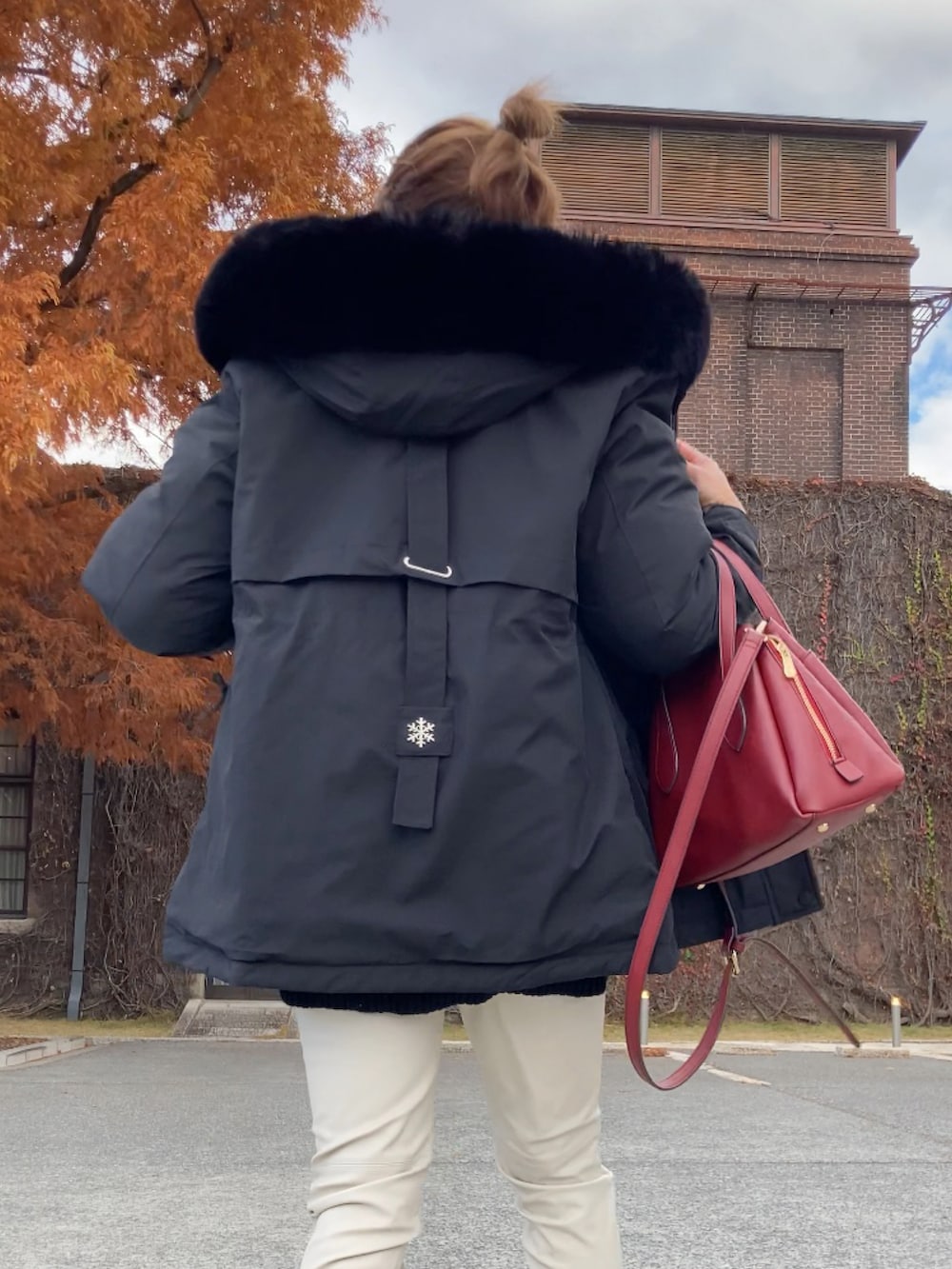 ブラック系のブルゾン、ブラック系のニット/セーター、ホワイト系のパンツを着用したレディースの冬コーディネートの3枚目の写真