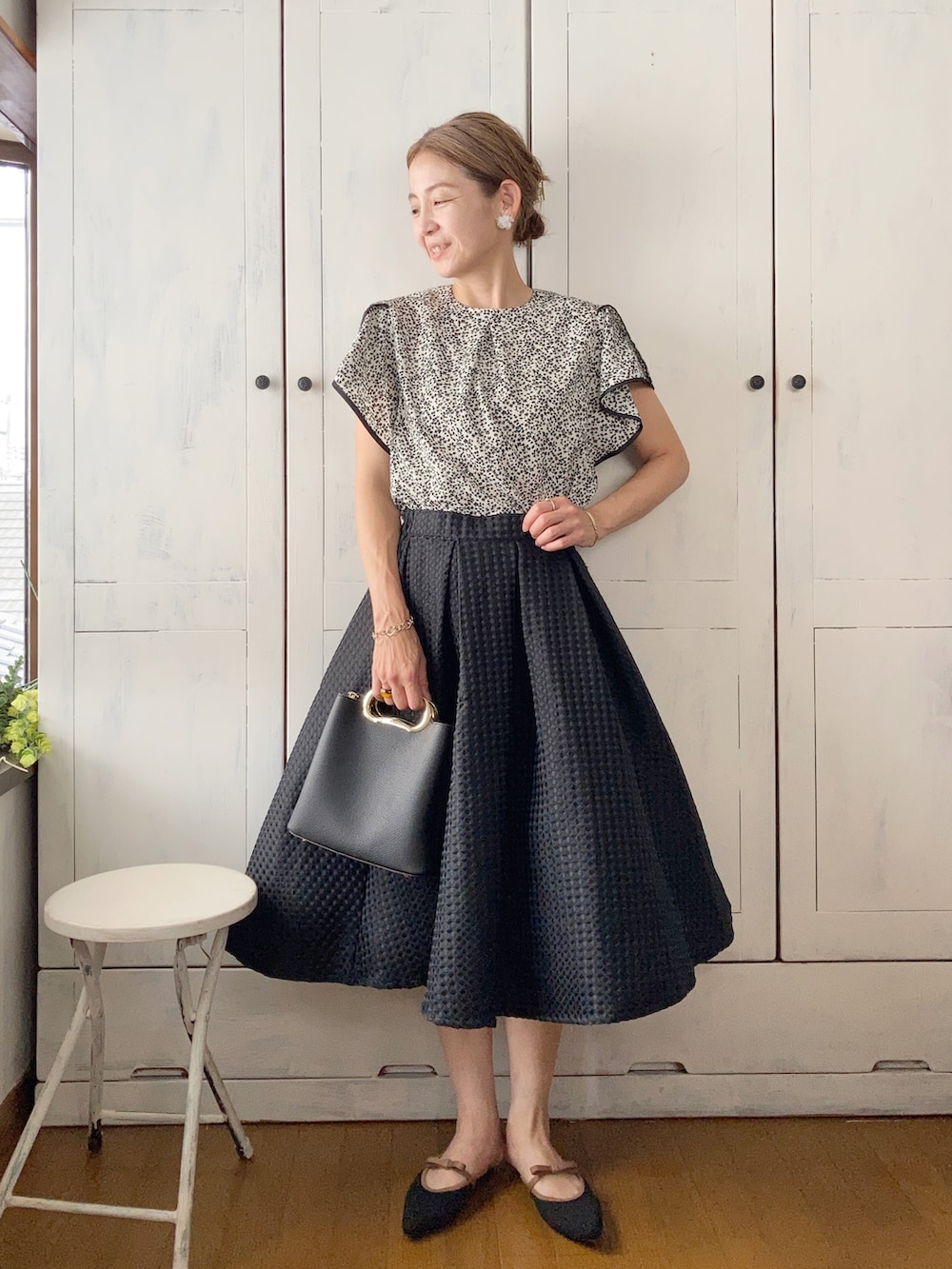 ブラック系のサンダル、ホワイト系のシャツ/ブラウス、ブラック系のハンドバッグを着用したレディースの夏コーディネートの2枚目の写真