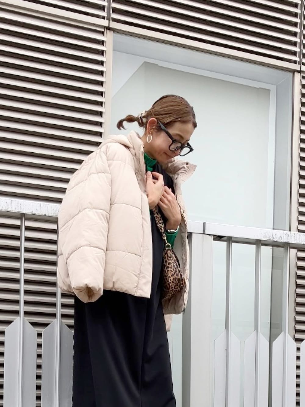 ブラック系のワンピース、グリーン系のニット/セーター、ブラウン系のショルダーバッグを着用したレディースの冬コーディネートの2枚目の写真