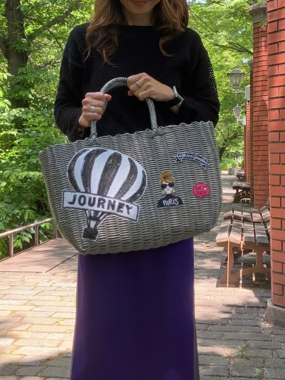 パープル系のスカート、グレー系のバッグ、ホワイト系のスニーカーを着用したレディースの春コーディネートの2枚目の写真