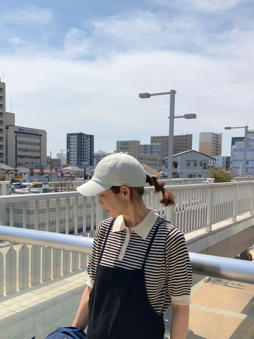 ブラック系のサロペット/オーバーオール、ブラック系のトップス、ブルー系のデニムジャケットを着用したレディースの春コーディネートの3枚目の写真