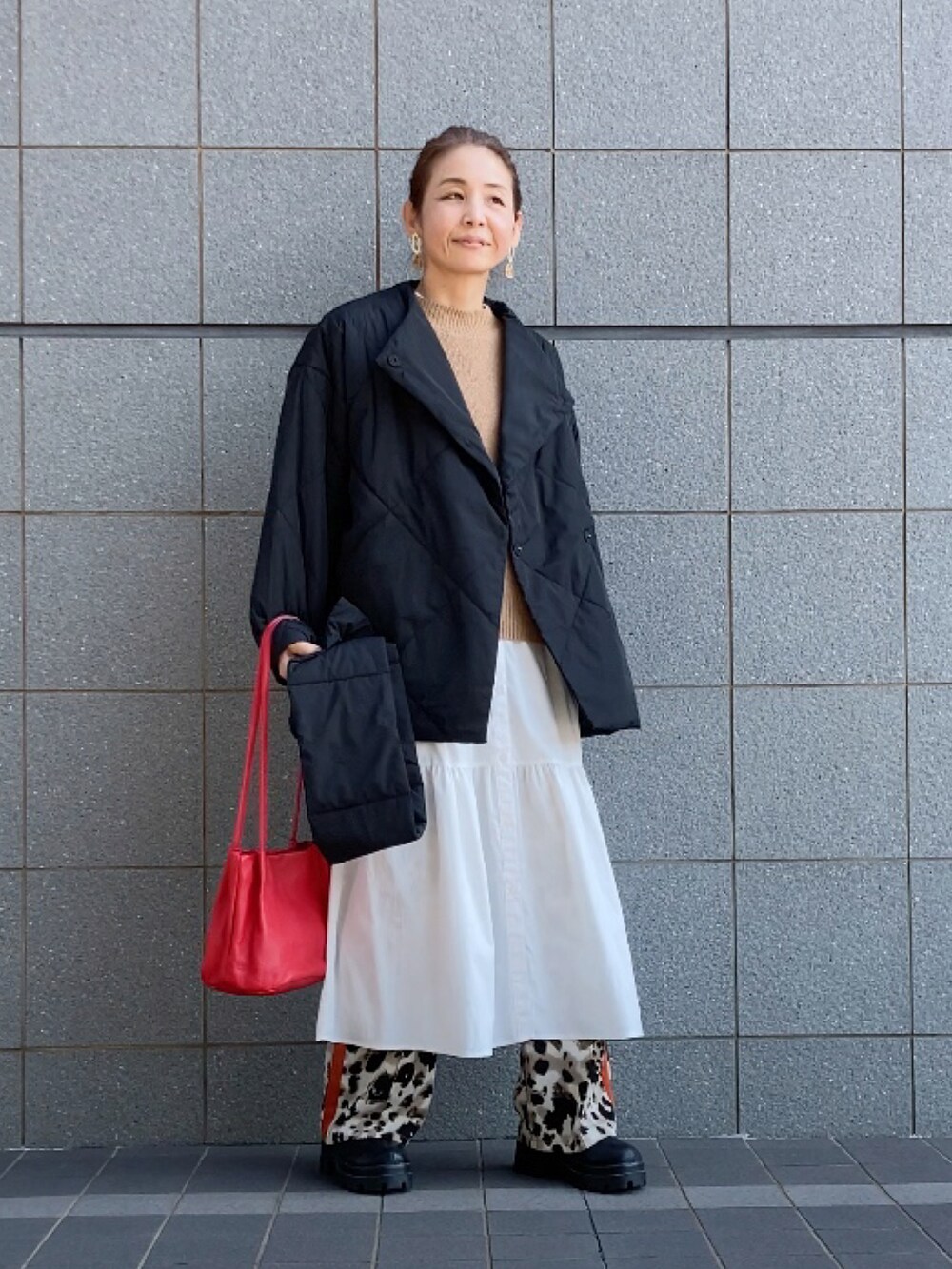 ブラック系のダウンジャケット/コート、ベージュ系のベスト、ホワイト系のワンピース/ドレスを着用したレディースの秋コーディネートの2枚目の写真