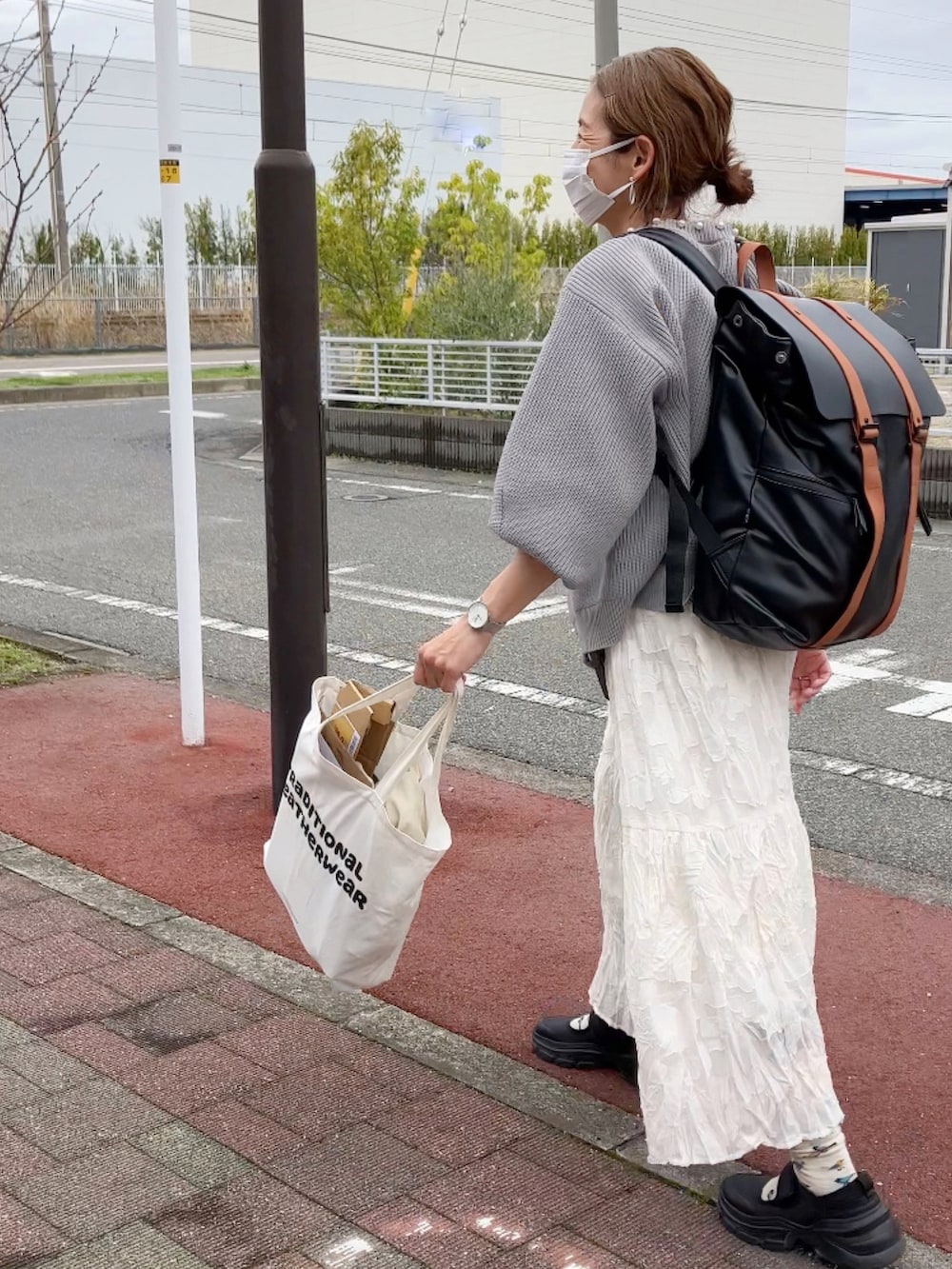 グレー系のカーディガン/ボレロ、ホワイト系のワンピース、ブラウン系のバックパック/リュックを着用したレディースの春コーディネートの5枚目の写真