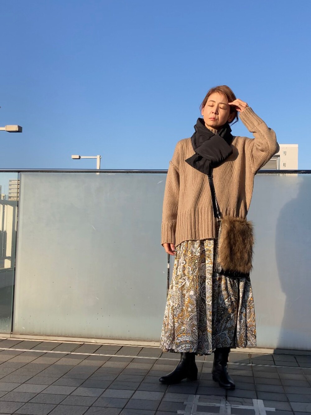 ベージュ系のニット/セーター、イエロー系のワンピース、ブラウン系のショルダーバッグを着用したレディースの秋コーディネートの4枚目の写真