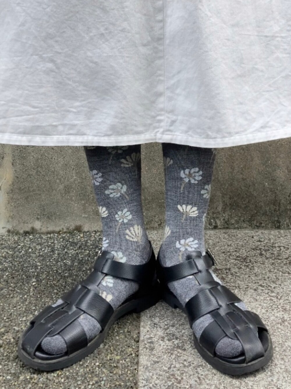 ブラック系のベスト、ホワイト系のワンピース、グリーン系のショルダーバッグを着用したレディースの夏コーディネートの4枚目の写真