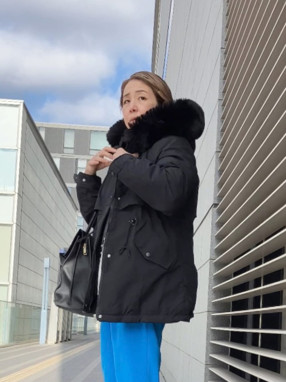 グレー系のカーディガン/ボレロ、ブルー系のその他パンツ、ブラック系のブルゾンを着用したレディースの冬コーディネートの4枚目の写真