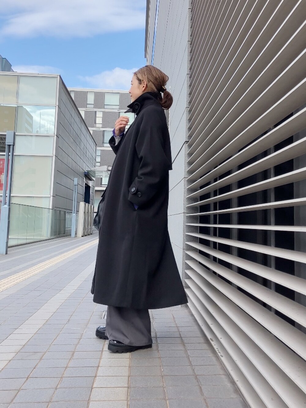 グレー系のカーディガン/ボレロ、ブラック系のステンカラーコート、グレー系のその他パンツを着用したレディースの冬コーディネートの4枚目の写真