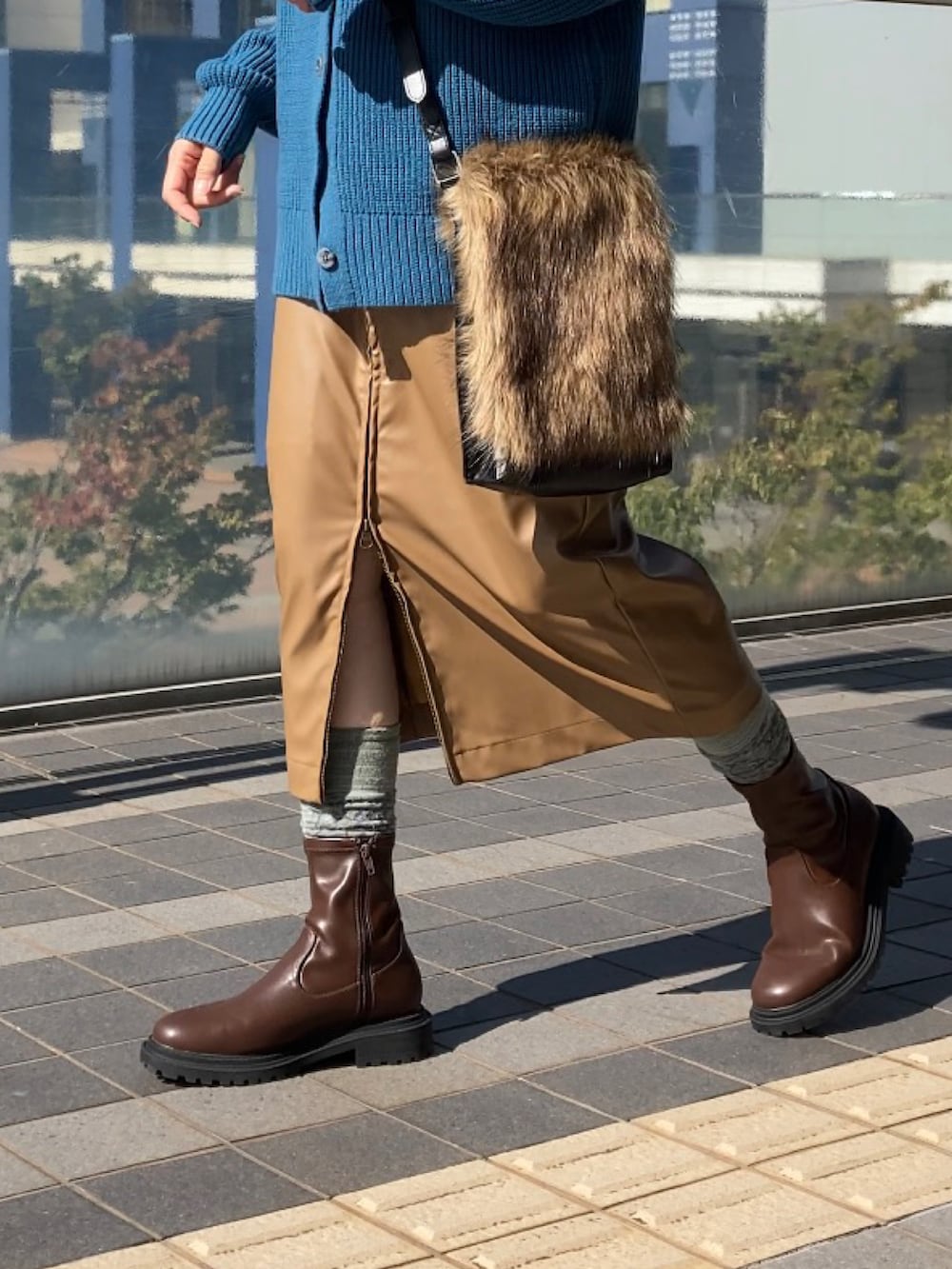 ブラウン系のブーツ、ブラウン系のスカート、ブルー系のニット/セーターを着用したレディースの秋コーディネートの2枚目の写真
