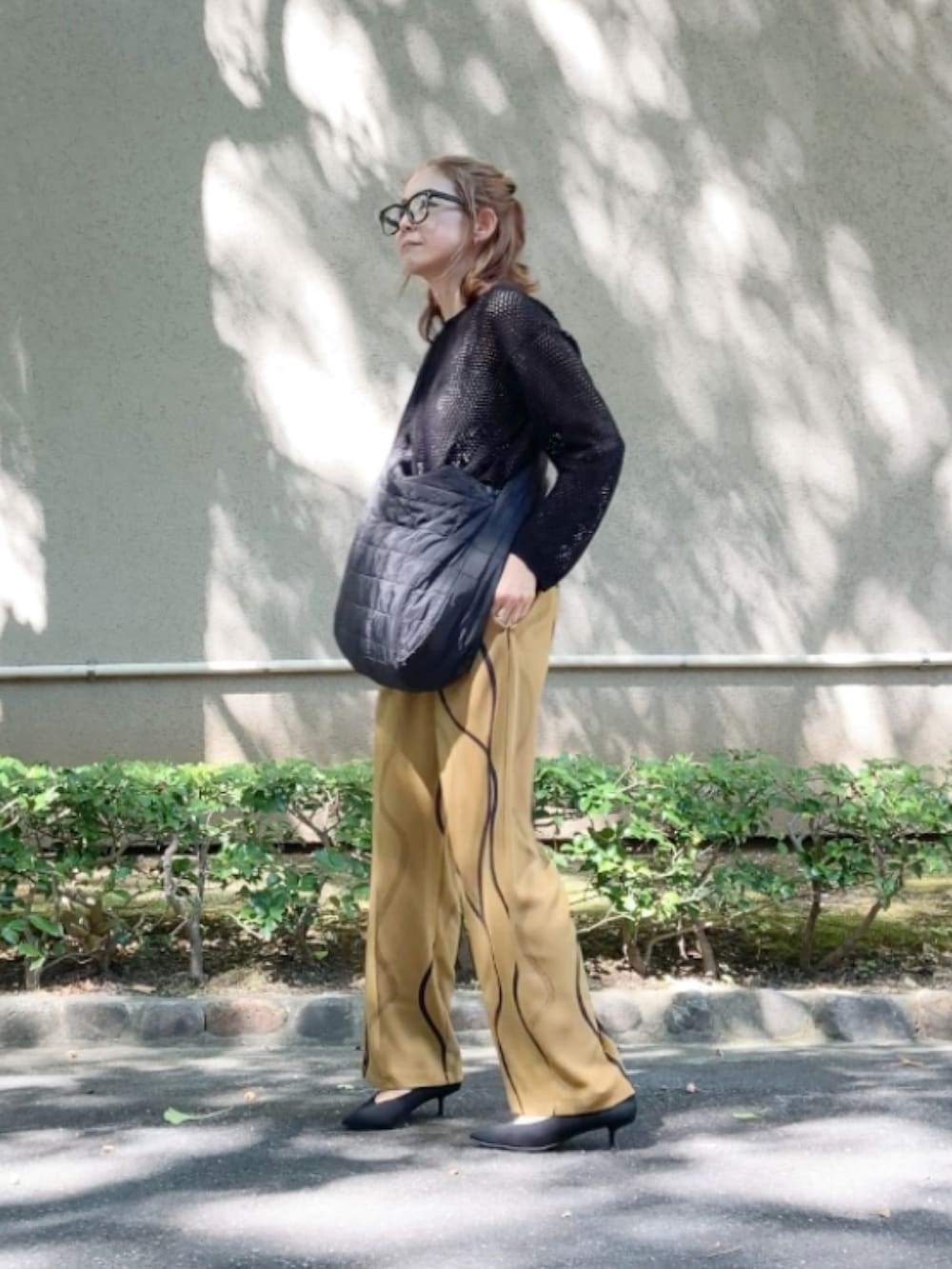 ブラック系のショルダーバッグ、イエロー系のその他パンツ、ブラック系のパンプスを着用したレディースの秋コーディネートの3枚目の写真