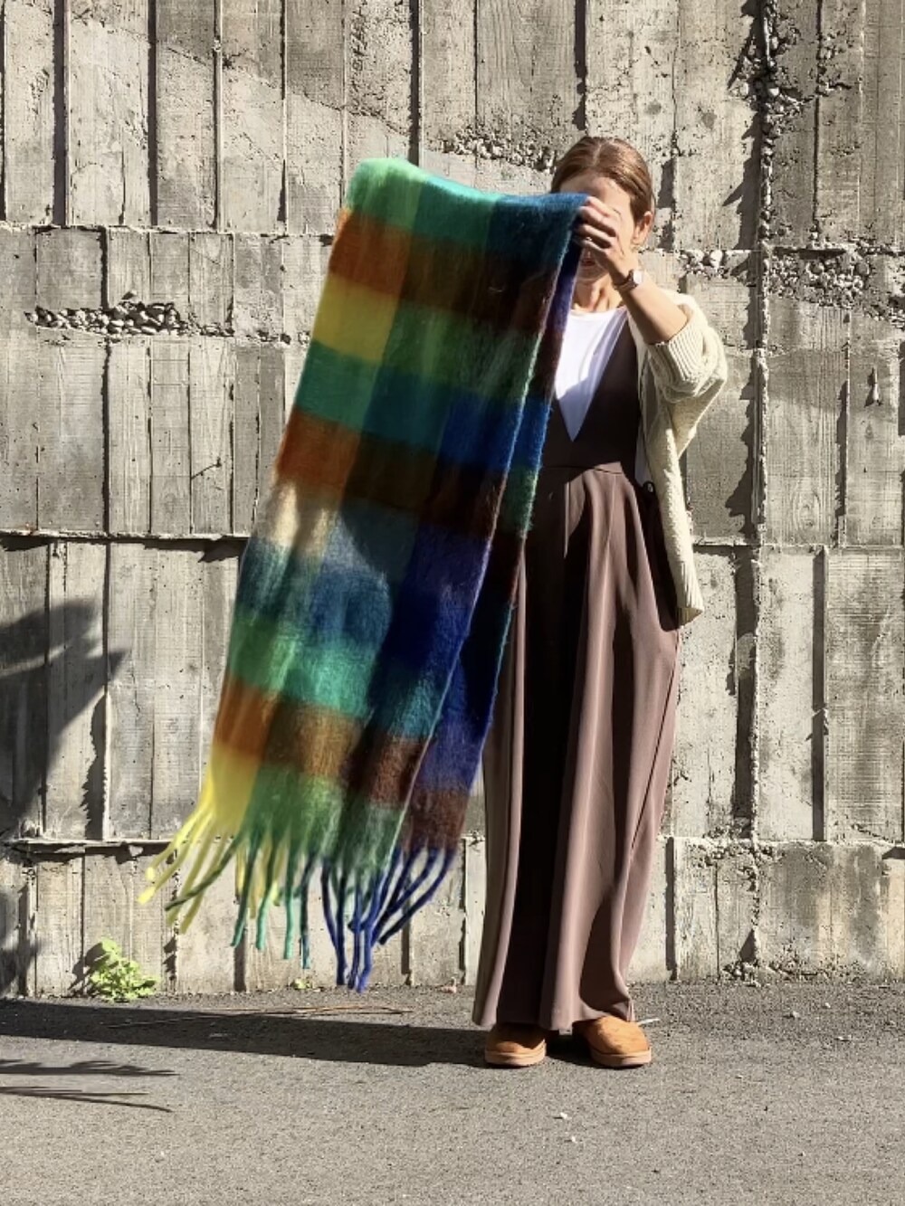 ブラウン系のサロペット/オーバーオール、ホワイト系のTシャツ/カットソー、ホワイト系のカーディガン/ボレロを着用したレディースの秋コーディネートの2枚目の写真