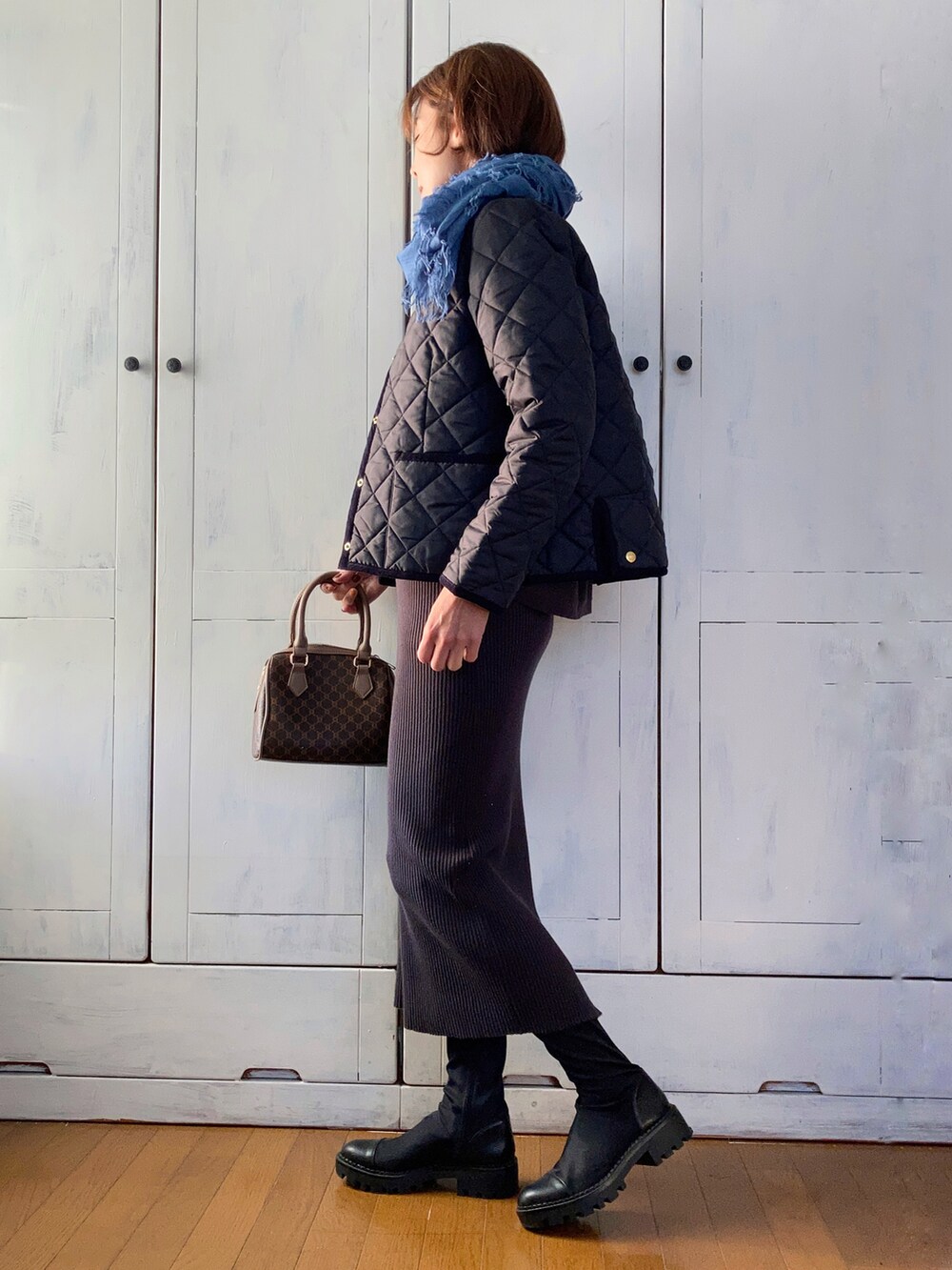 ブルー系のノーカラージャケット、グレー系のワンピース、ブラウン系のボストンバッグを着用したレディースの秋コーディネートの2枚目の写真