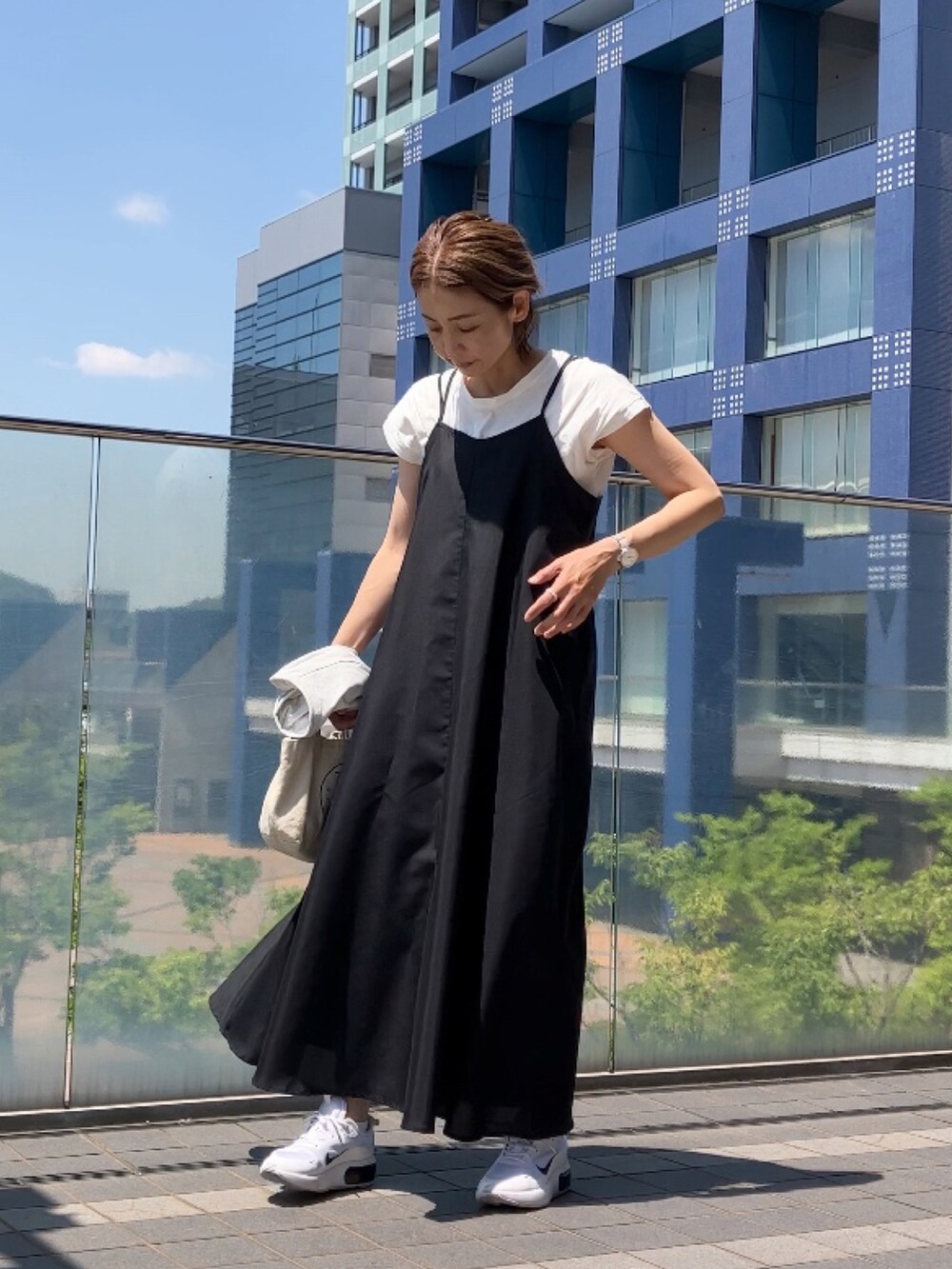 ブラック系のワンピース/ドレス、ホワイト系のTシャツ/カットソー、ホワイト系のスニーカーを着用したレディースの春コーディネートの5枚目の写真