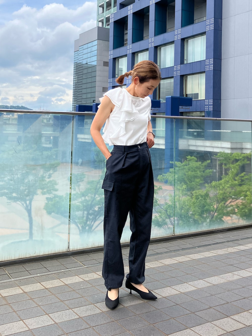 ブラック系のカーゴパンツ、ホワイト系のTシャツ/カットソー、ブラック系のパンプスを着用したレディースの夏コーディネートの3枚目の写真