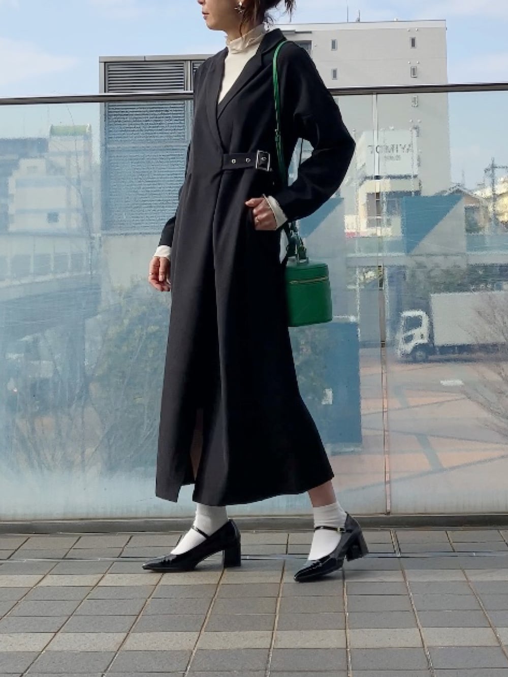 ブラック系のシャツワンピース、ホワイト系のTシャツ/カットソー、グリーン系のショルダーバッグを着用したレディースの冬コーディネートの3枚目の写真