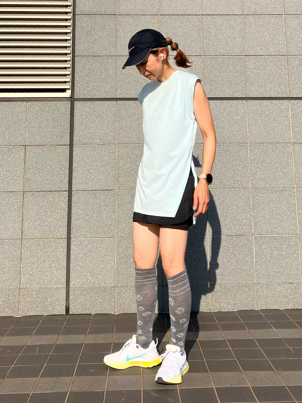 ブラック系のワンピース、ブルー系のTシャツ/カットソー、ホワイト系のスニーカーを着用したレディースの夏コーディネートの4枚目の写真